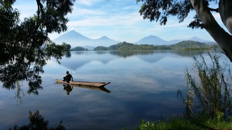 Dugout canoe on Lake Mutanda with volcanoes behind